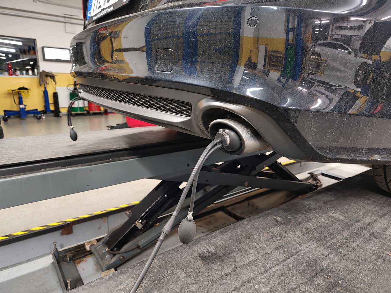 Rauchtester am Auspuffendrohr zur Dichtheitsprüfung der Abgasanlage und Suche nach möglichen Abgasleckstellen bei J&S SERVIS.
